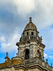 Stone bell tower with dome against cloudy sky