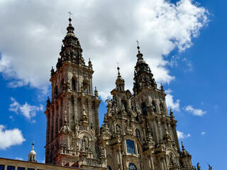 Baroque cathedral towers under clouds on a sunny day