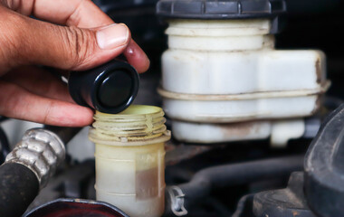 Check brake fluid,Hand open a tank for car maintenance.