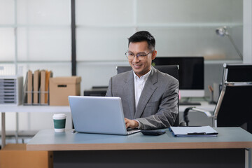 Businessman using laptop computer in office. Happy man, entrepreneur, small business owner working...
