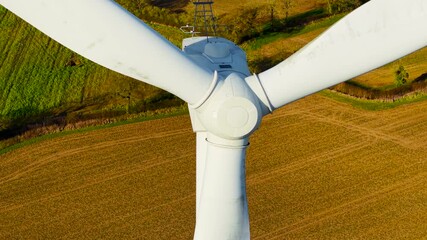 Large rotor wind electric generator. Wind turbine rotating energy blades to deliver carbon neutral power. Spinning energy blades supplying green electricity on wind farm - Powered by Adobe