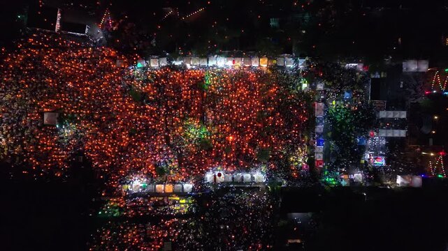 Aerial view of the Parangtritis Lantern Festival, a vibrant display of lanterns illuminating the night sky with orange and green hues, Yogyakarta, Special Region of Yogyakarta, Indonesia.