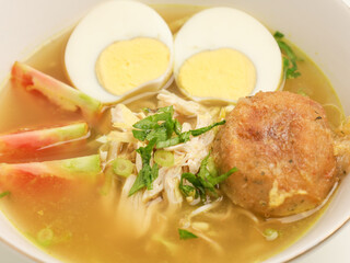 Soto Ayam or chicken soup cooked in chicken broth served with boiled egg, shredded chicken, bean sprout, fried mashed potato