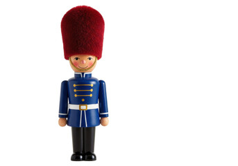 Isolated toy figurine of a wooden soldier in traditional uniform and red bearskin hat, toy shop