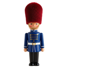 Isolated toy figurine of a wooden soldier in traditional uniform and red bearskin hat, toy shop