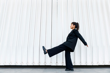 Businesswoman strikes aesthetic pose in front of modern architecture