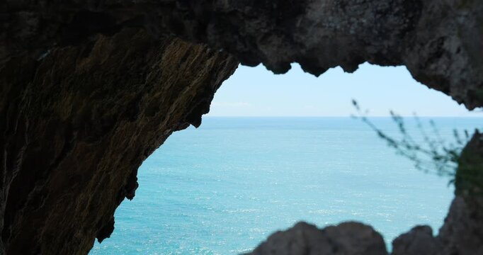 View of Mediterranean Sea from inside Grotta dei Falsari, Cave of Forgers, rock formations and coastline, Noli, Italy