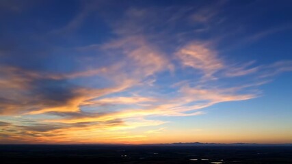 ﻿Fast moving clouds transforming from day to twilight across a vibrant sky timelapse majestic, abstract, transition