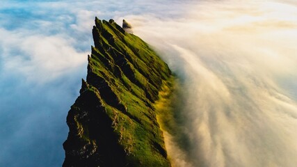 Drangarnir Sea Stacks in the Faroe Islands with fog, Tindholmur on the Faroe Islands, Vagar, aerial drone view during the day in the North Atlantic Ocean. Faroe Islands, Denmark, Europe.