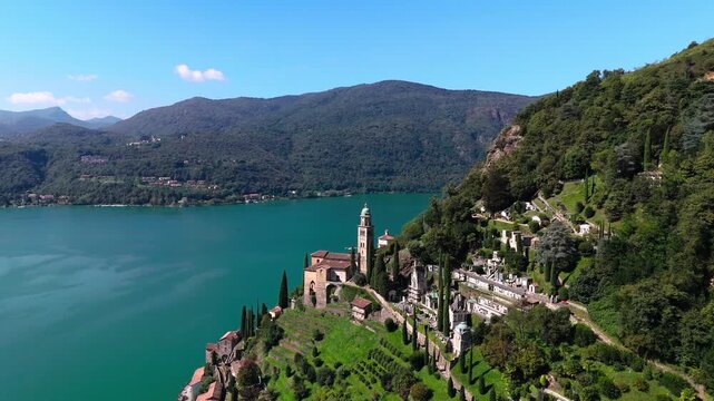 Drone view of church in Switzerland at Lake Lugano, Italy in background