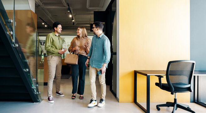 Young professionals walking and conversing in a modern creative office environment