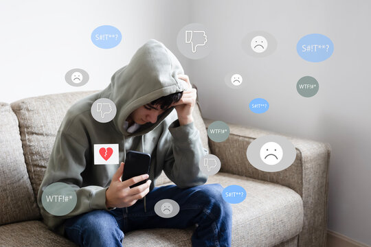 Teen mental health problem, social media harassment concept. A preteen schoolboy, teenager using smartphone alone feeling frustrated after reading bad comments, text negative emoticons.