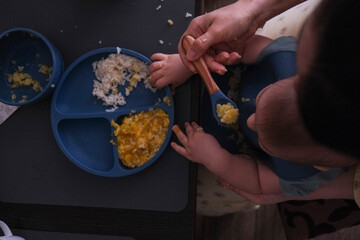 Baby Eating Rice and Eggs with Spoon overhead