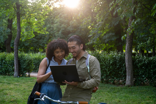 Interracial couple using laptop in park