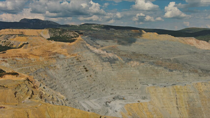 Aerial of open mine and heavy mining equipment