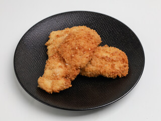 Chicken Katsu on black plate and white background
