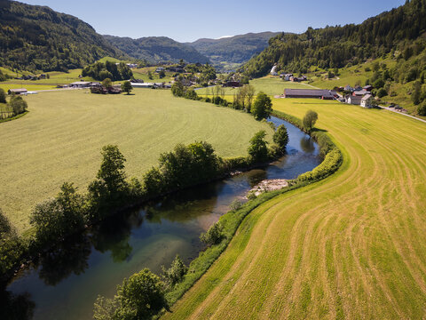 Aerial drone photo of Viksdalen valley, Norway, showing the Gaula river, green farmland, and the famous Huldrefossen waterfall.