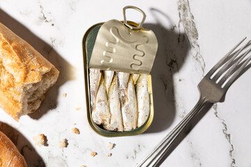 Canned sardines and bread isolated on kitchen countertop