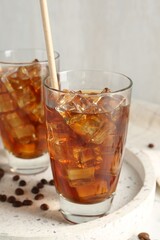 Tasty iced coffee and beans on table, closeup