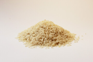 Close-up of a pile of raw oval-shaped rice grains isolated on a white background. Natural uncooked rice texture, perfect for illustrating food, agriculture, and healthy eating concepts.