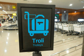 Blue luggage trolley sign at airport for baggage carousels and trolleys