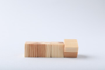 Blank wooden cubes on light background, closeup. Space for text
