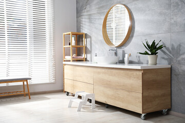 Stylish bathroom with round mirror over sink. Interior design
