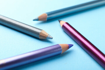 Eye pencils on light blue background, closeup