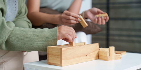 Close-up of mother and daughter assembling wooden blocks together