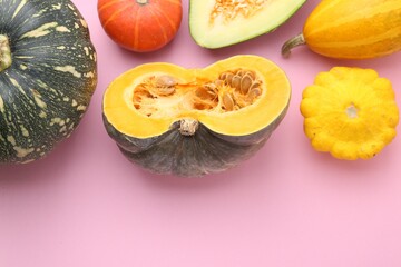 Many fresh pumpkins and other gourds on pink background, flat lay. Space for text