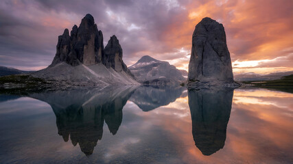 Stunning mountain lake reflection with rocky peaks and colorful sunset sky