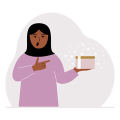 A woman holds a jar of cream in his palm.