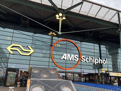 New AMS Schiphol Airport logo on modern glass airport building and baggage trolleys  26 October 2025, Netherlands