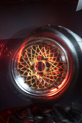 old retro stylish wheels collapsible two-component with a gold center and shiny rims for car tuning long exposure photo to simulate movement