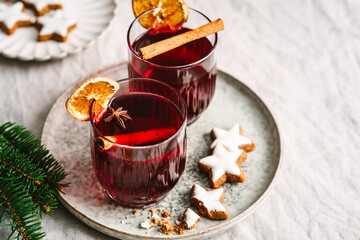 Stillleben von zwei Gläser Glühwein mit Orange und Zimtstange auf einem Serviertablett. Modern, Weihnachten, Heißgetränk.