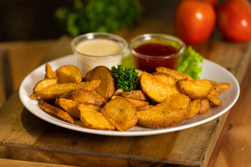 Golden crispy potato wedges served on a white plate with ketchup and creamy mayonnaise. Perfect for fast food advertising, snack menus, and culinary branding visuals.