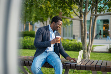 Obraz premium Young black man working on laptop outdoors