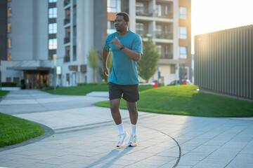 Black man running outdoors promoting health and wellness