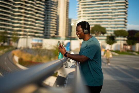 African american man smiling using smartphone with headphones