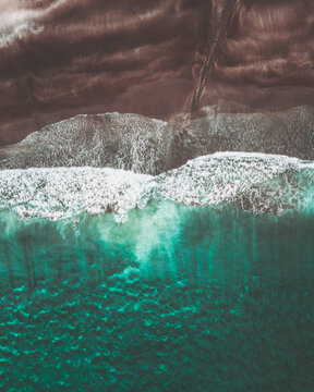Aerial view of the dramatic contrast between the dark volcanic sand and the turquoise ocean where the waves crash, Tj&Atilde;&cedil;rnuv&Atilde;&shy;k, Streymoy, Faroe Islands.