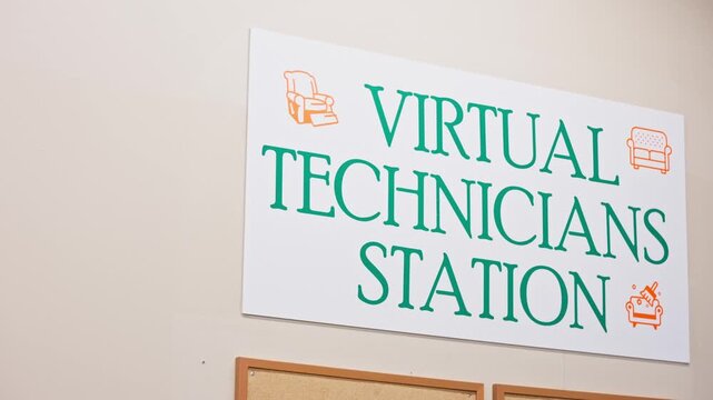 Camera pans slowly across Virtual Technicians Station sign in industrial workshop