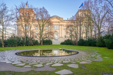 Berlin, Germany - December 20, 2019: Memorial honoring Sinti and Roma stands beside Reichstag Building in early morning light