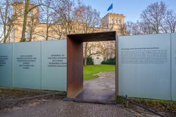 Berlin, Germany - December 20, 2019: Memorial honoring Sinti and Roma stands beside Reichstag Building in early morning light