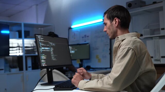 Programmer coding on computer screen in modern tech office. Perfect for software development, IT job, startup workspace, cybersecurity, or remote work and coding lifestyle visuals