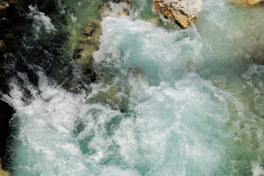 dettagli da sopra del flusso dell'acqua color verde smeraldo del fiume Isonzo, in Slovenia, di giorno, in primavera