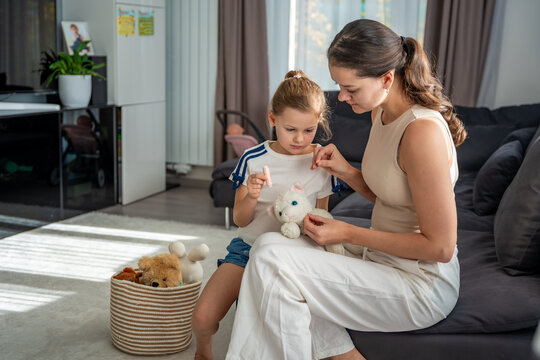 Mother and daughter repairing an old plush toy together. Sustainable lifestyle, mindful consumption, and conscious parenting at home