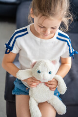 Portrait of a child holding a well-worn soft toy in their hands. Emotional attachment to a beloved...