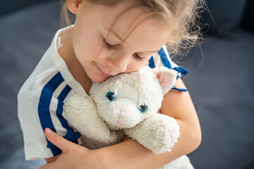 Portrait of a child holding a well-worn soft toy in their hands. Emotional attachment to a beloved...