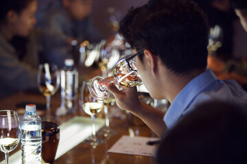 Back View Portrait of Sommelier Tasting White Wine at Wine School