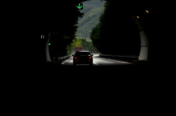 Shouzu, China, 2 May 2019: Car Emerging from Dark Tunnel into Scenic Mountain Road Surrounded by Green Forests in China